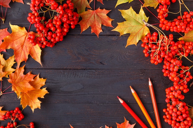 Foto foglia di autunno sulla foglia arancio del fondo nero di legno sulla piattaforma di legno di vecchio lerciume, posto della copia per l'iscrizione, vista superiore, compressa per testo