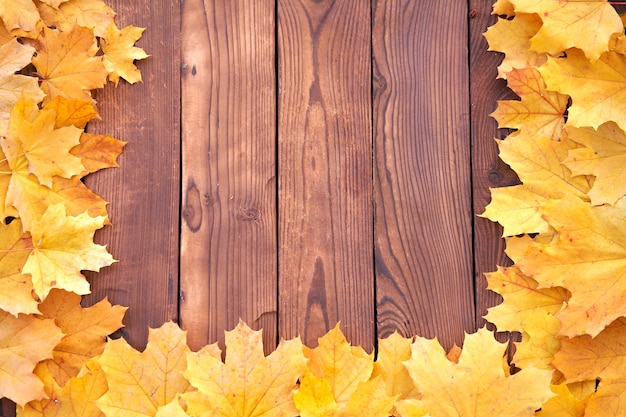 Autumn leaves frame on wooden background top view Fall Border yellow and Orange Leaves vintage wood table Copy space for text