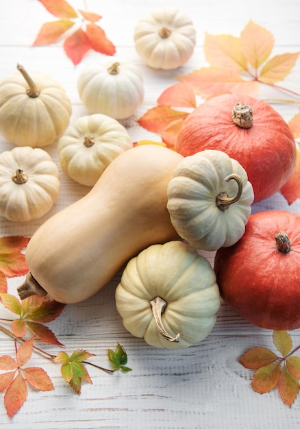 Autumn leaves and pumpkins over old wooden background