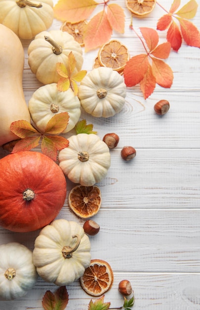 Autumn leaves and pumpkins over old wooden background