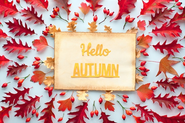 Autumn leaves. Text Hello Autumn on ager paper, flat lay