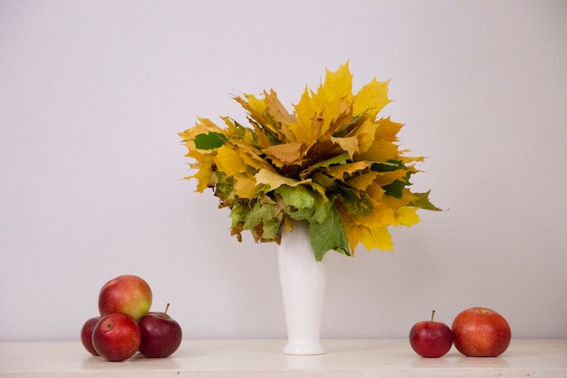 Foto foglie d'autunno in un vaso bianco