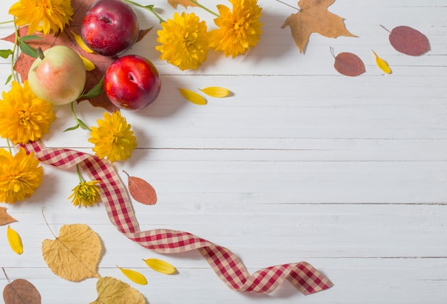 Fogli di autunno sulla parete di legno bianca