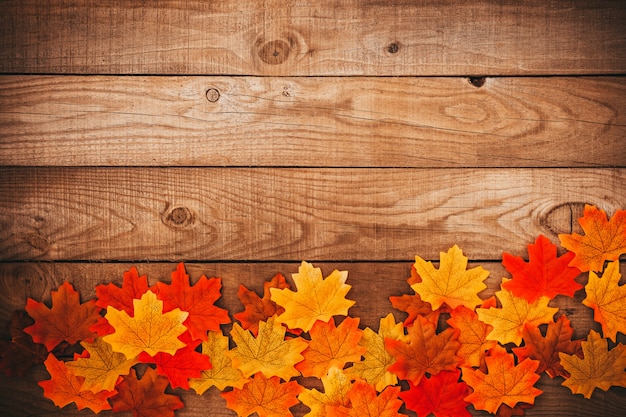 Autumn maple leaves over old wooden background