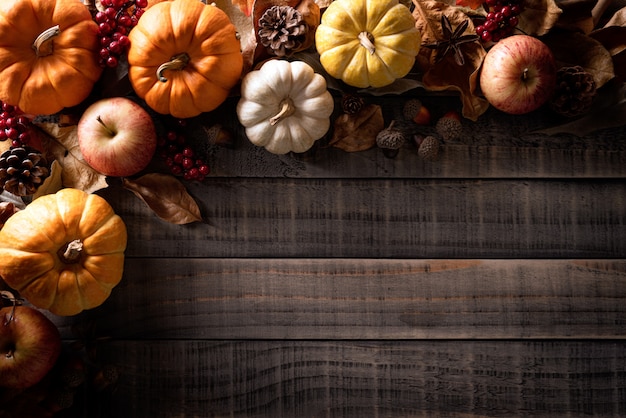 Autumn maple leaves with Pumpkin, apple on wood