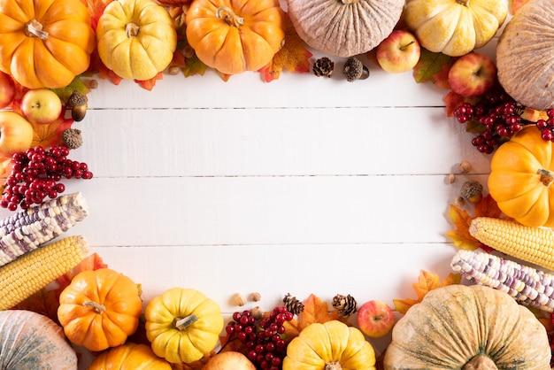 Photo autumn maple leaves with pumpkin and red berries, thanksgiving day concept.