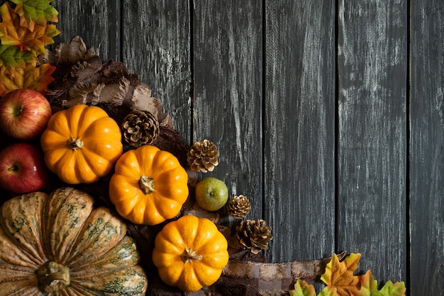 Autumn maple leaves with Pumpkin and red berries on wooden background. Thanksgiving concep