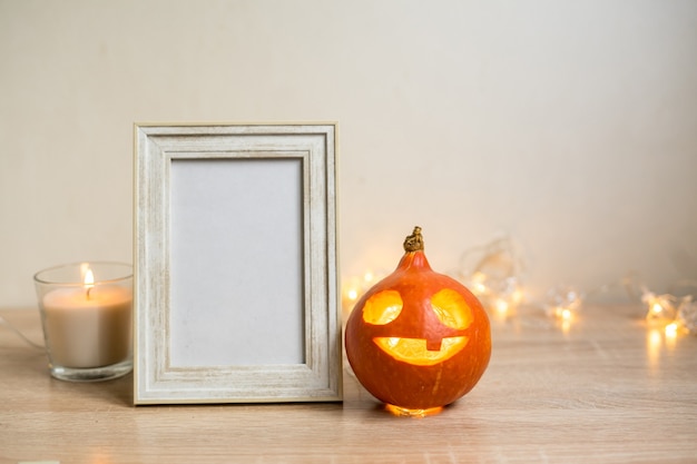 Composizione minima autunnale. concetto di festa del ringraziamento. cornice per foto, zucca su sfondo bianco. vista frontale, copia dello spazio. foto di alta qualità