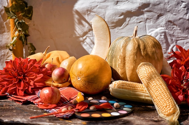 Autumn modern still life with trendy shadows yellow vegetables fruits and bright paints with a brush pumpkin pears apple and melon Autumn red georgine decoration Thanksgiving Day concept