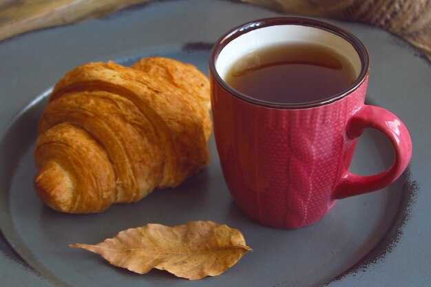 Autumn mood french breakfast composition cup of tea and croissants