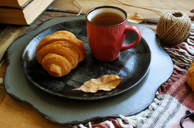 Autumn mood french breakfast composition cup of tea and croissants