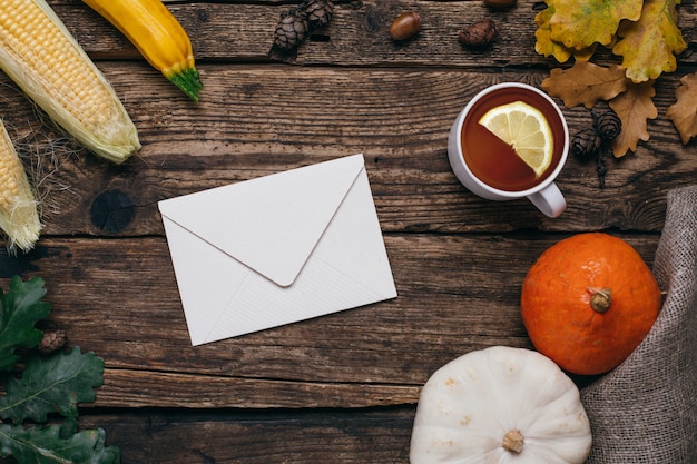 Autumn mood: letter , pumpkins and corn with yellow leaves on wood