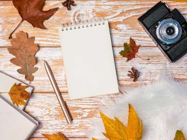 Autumn mood mockup top view spiral notebook with copy space framed with fallen leaves and vintage