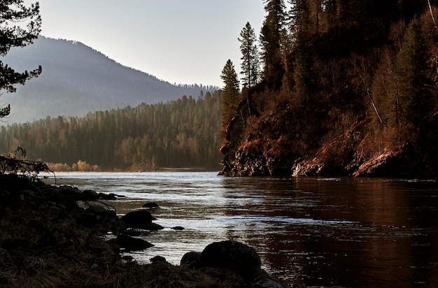 Autumn morning landscape The river flows between a wooded mountain