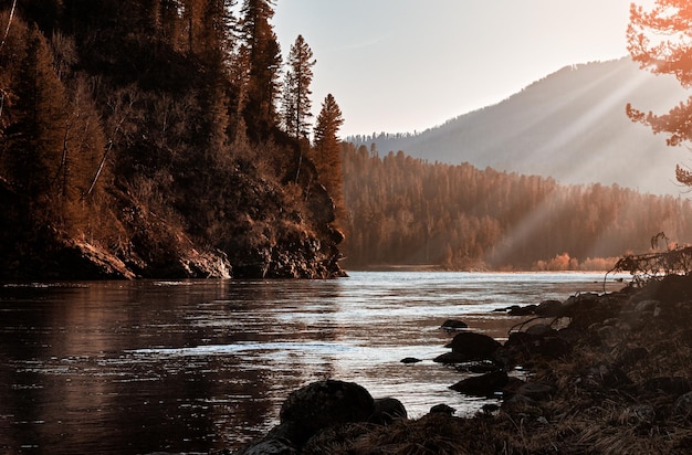 Autumn morning landscape The river flows between a wooded mountain