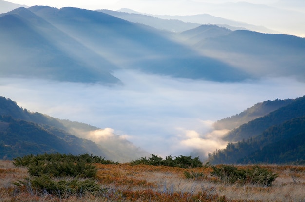 写真 太陽光線と霞のある秋の朝の山の景色