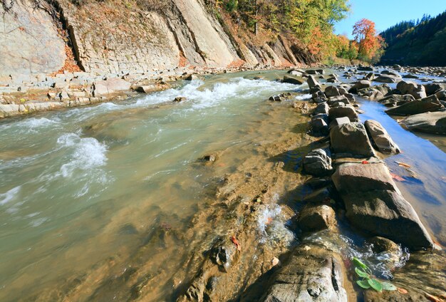 Autumn mountain stony river view with some rapids and stony edges