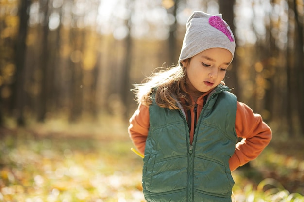 Ritratto all'aperto di autunno della bella ragazza felice del bambino nella foresta