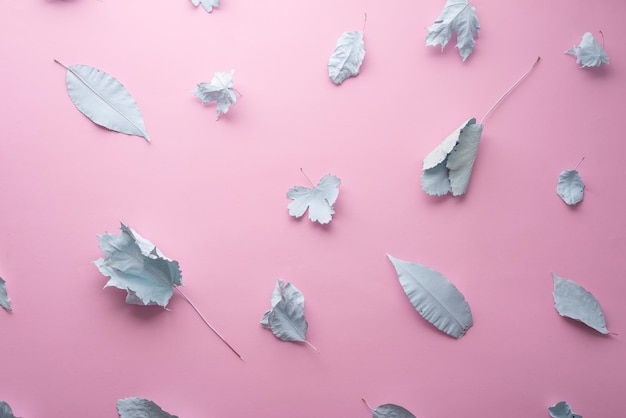 Autumn pastel background blue leaves in paint on a pink background