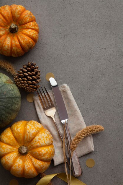 Autumn place setting lifestyle thanksgiving background with cutlery and pumpkins