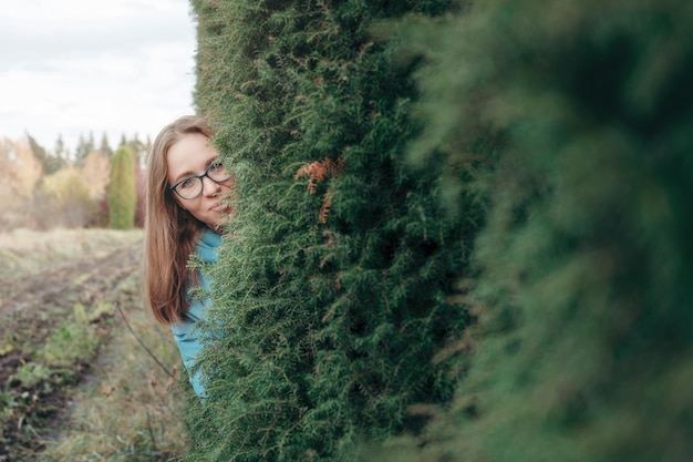 Autumn portrait of beautiful woman on thuja nature background