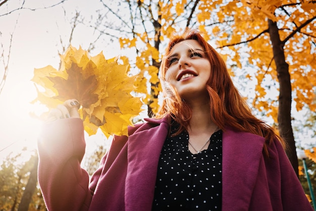 Осенний портрет откровенной красивой рыжеволосой девушки с осенними листьями в волосах