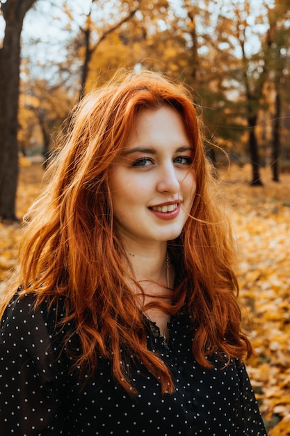 Autumn portrait of candid beautiful redhaired girl with fall leaves in hair