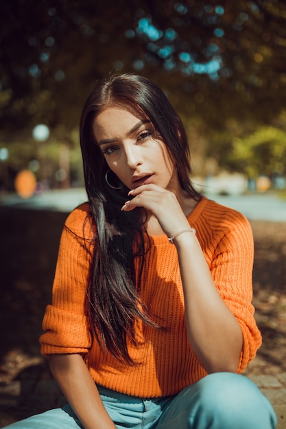 Photo autumn portrait of fashionable young woman looking at camera