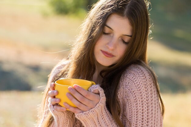 Autumn portrait of a girl with a yellow cup