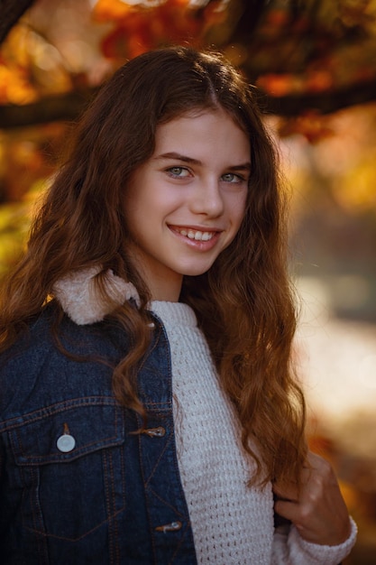 Autumn portrait of happy lovely and beautiful Caucasian girl in forest in fall colors Concept of autumn mood