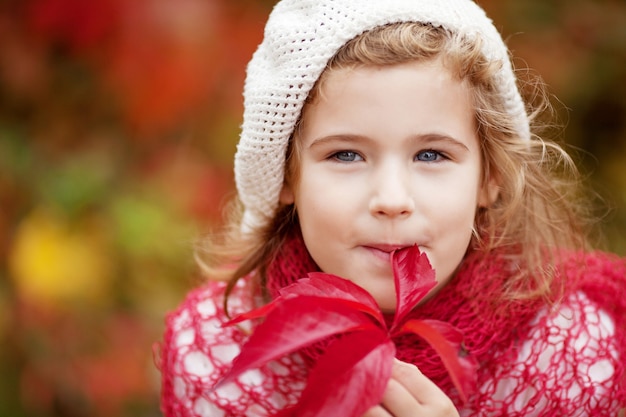 Autumn portrait of little  girl. Pretty little girl with red grape leaves in autumn park. Autumn activities for children. Halloween and Thanksgiving time fun for family.