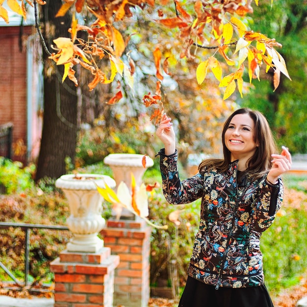 若い幸せな女の秋の肖像画。黄色の紅葉。幸せな美しい人々。ライフスタイル。秋