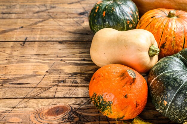 Autumn pumpkin frame in Halloween colors orange. Wooden background. Top view. Copy space.