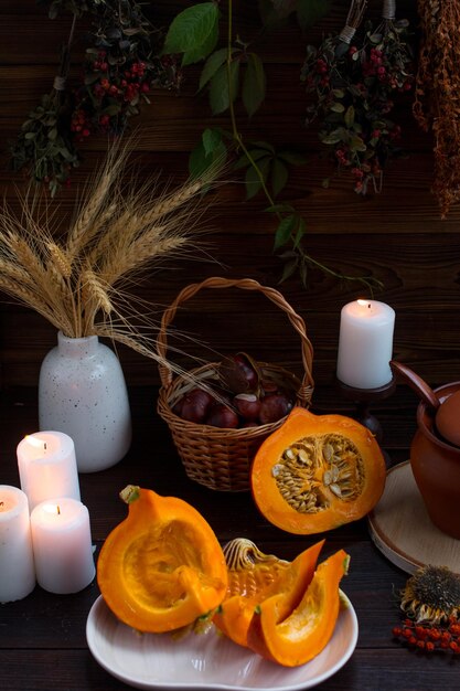 autumn pumpkin sliced on a wooden table Romantic candlelit dinner dry spikelets Village Concept