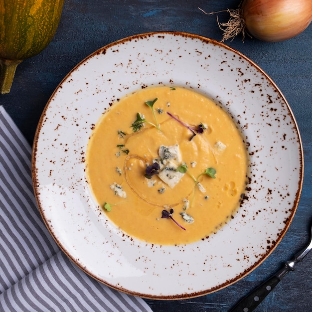 Zuppa di zucca autunnale con formaggio blu su un piatto vista dall'alto