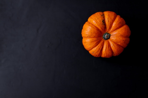 秋のカボチャ感謝祭の背景-黒いテーブルの上のオレンジ色のカボチャ