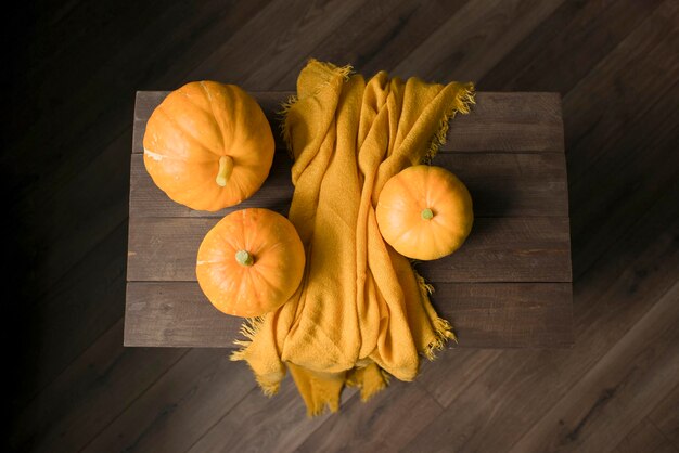 Autumn pumpkins and a blanket on a wooden table