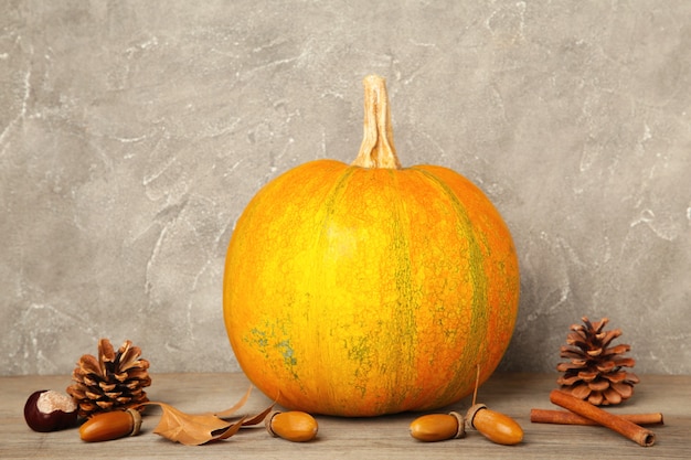 Autumn pumpkins with autumn harvest on grey background. Top view