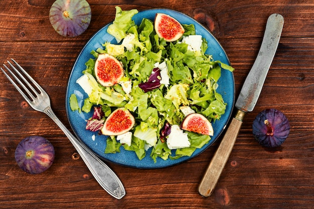 Autumn salad with figs rocket salad and cheese on rustic wooden background Fig salad