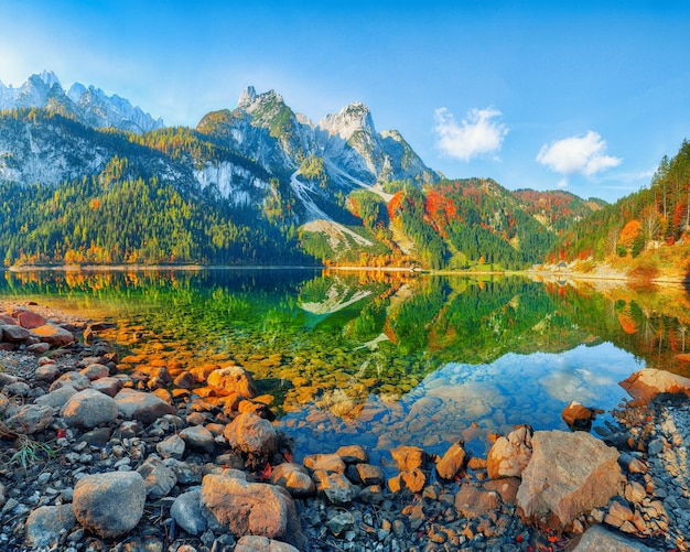 Autumn scenery with Dachstein mountain summit reflecting in crystal clear Gosausee mountain lake