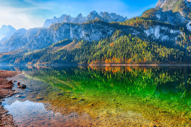 Autumn scenery with Dachstein mountain summit reflecting in crystal clear Gosausee mountain lake