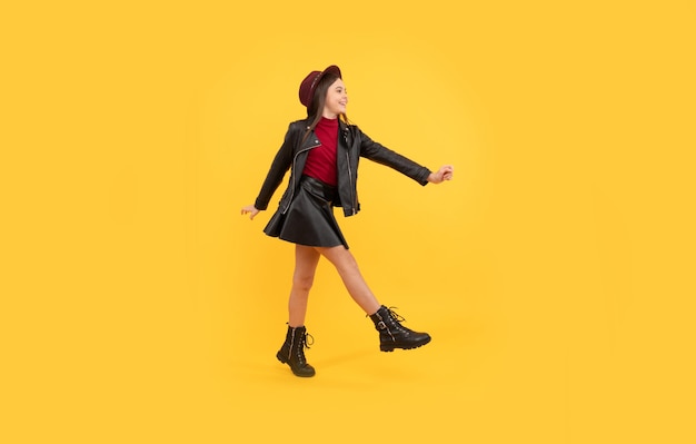 Autumn season trends fall seasonal sales back to school tween hurry up childhood happiness happy girl in leather wear dancing stylish teen child making wide step kid in hat and boots running