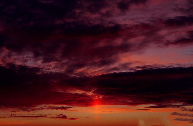 暗い雲と金色のハイライトを持つ夕方の薄紫色のパレットの秋の空の背景