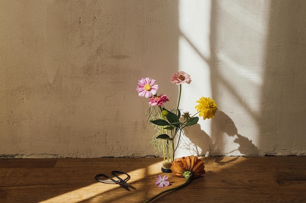 Autumn still life Autumn flowers composition and scissors in sunny light in modern rustic room