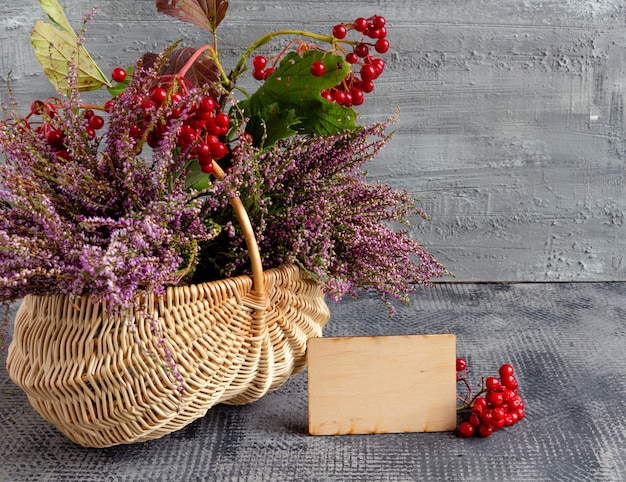 Autumn still life basket with heather and viburnum and empty postcard thanksg