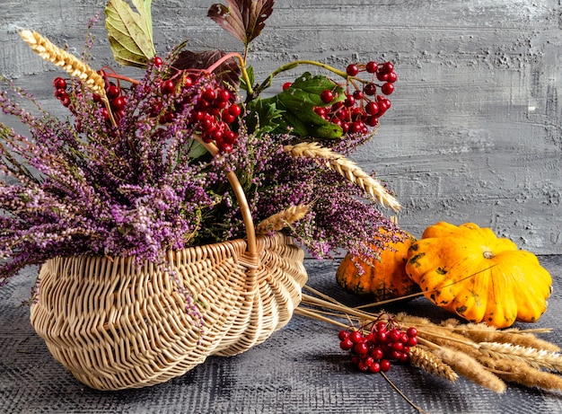 Autumn still life basket with heather and viburnum and fruits thanksgiving day