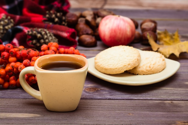 Autumn still life  coffee, cookies, a plaid, a notebook and a pencil on wood