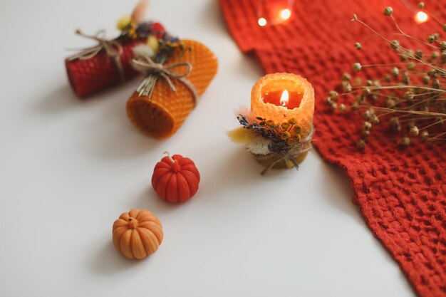 Natura morta autunnale e arredamento accogliente con candele e tessuto hygge lifestyle