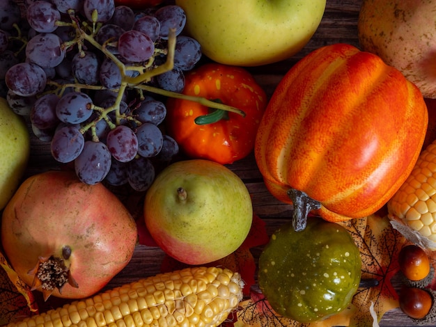 Foto natura morta autunnale diversi tipi di frutta e zucca sul tavolo di legno