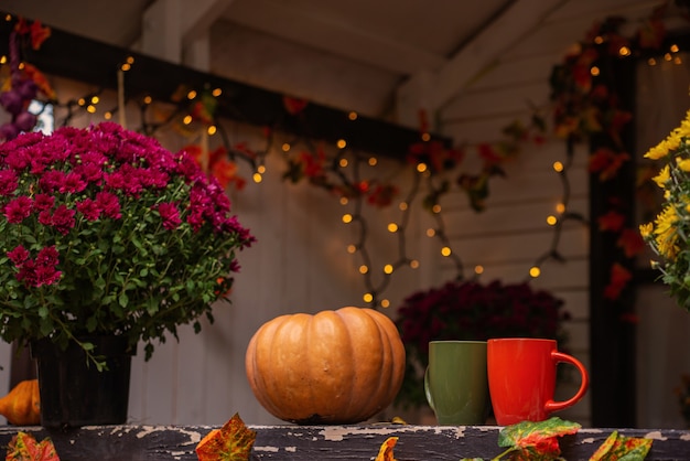 Autumn still life with a cup of tea pumpkins flowers Thanksgiving or halloween concept